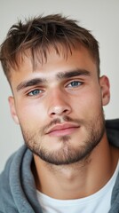 Obraz premium Hopeful expression of a young man in casual hoodie - stock portrait for inspiration and motivation