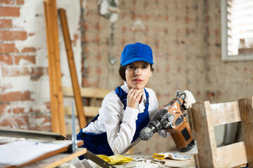 Woman in workshop with industrial puncher at construction site