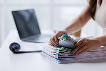 Adult businesswoman or auditor examining documents and laptop. financial document reports,...