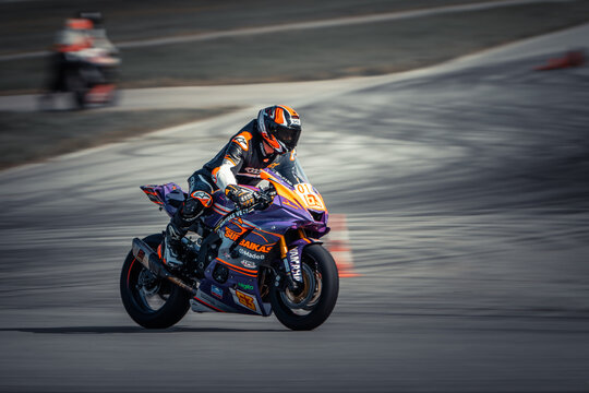  A man rides pillion on a motorcycle following one in front during a race