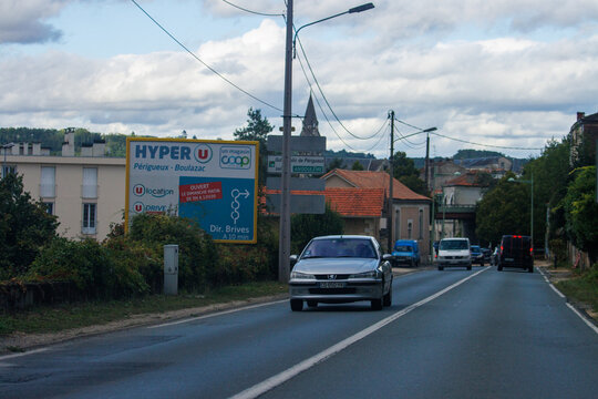 France, 8 September 2024: Cars driving on a suburban road with a Hyper U store sign.