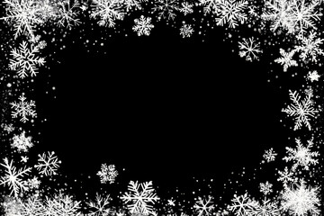 Festive frame made of snowflakes falling on black background. Border with copy space. Winter wallpaper