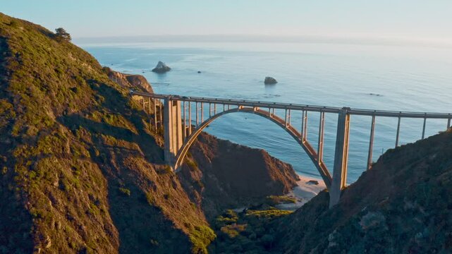 4k aerial footage of Bixby Creek Bridge on the Big Sur coast of California, USA. Ocean waves . Road to the San Francisco at sunset by a rocky coast. Stunning architectural in the natural landscape