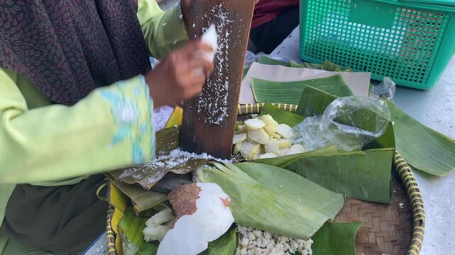 The process of grating coconut for a delicious lupis cake topping. Still fresh straight from traditional street vendors. Traditional Javanese food.