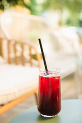 A glass of refreshing berry lemonade on the terrace of a cafe on a summer's day.