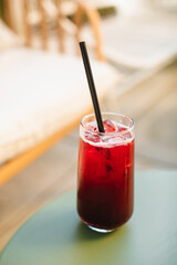 A refreshing blackberry drink on a cafe table outdoors in summer.