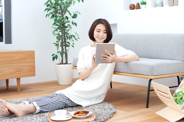 リビングでタブレットを操作する女性