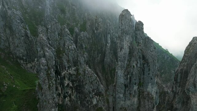 A Breathtaking View of the Jagged, Rugged Peaks of Mount Grignetta, Shrouded in Mist, in Lombardy, Italy - Pan Up Shot