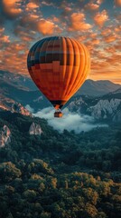 Naklejka premium Hot air balloon soaring over green mountain peaks at sunset