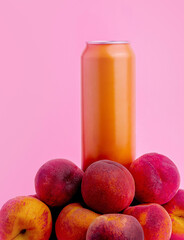 Orange aluminum can standing on pile of peaches on pink background