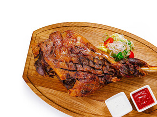 Roasted lamb leg with vegetables on wooden cutting board