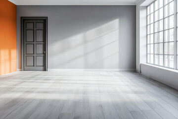 Fototapeta premium Spacious empty room with orange accent wall and large windows illuminating the hardwood floor during daylight hours