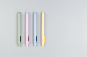 Top view of colorful pens on grey background. School, office wallpaper. Flat lay, copy space.