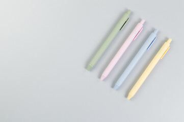 Top view of colorful pens on grey background. School, office wallpaper. Flat lay, copy space.