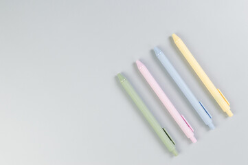 Top view of colorful pens on grey background. School, office wallpaper. Flat lay, copy space.
