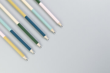 Top view of colorful pencils on grey background. School, office, art wallpaper. Flat lay, copy space.