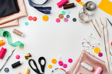 Crafting supplies arranged on a table with fabric, thread and buttons during daytime