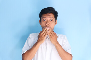 Shocked young Asian man with hand on his mouth