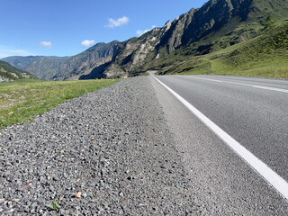 A winding road through the mountains on a sunny day.