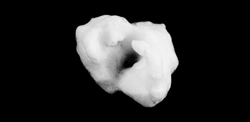 White soapy foam texture. Shampoo foam with bubbles.White facial foam creamy bubble soap sponge isolated on black background.