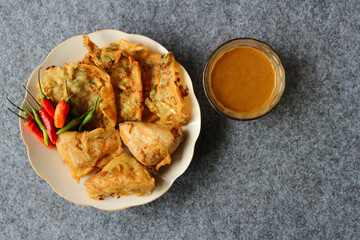 Typical Indonesian fried food, Bakwan sayur and Tahu isi sayur, served with spicy peanut sauce. on...