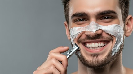 Young man happily shaving his face with cream in a well-lit bathroom mirror on a sunny morning