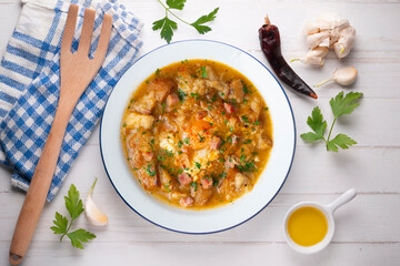 Castilian soup with vegetables, bread croutons and egg. Top view table with  decorations.