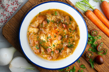 Castilian soup with vegetables, bread croutons and egg. Top view table with  decorations.