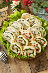 Creative appetizers christmas. Cheese roll with cream cheese, sweet pepper and greens.