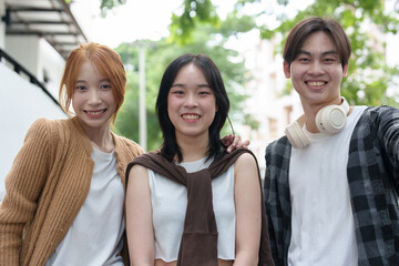 Attractive Asian college students using laptop, tablet, mobile phone to study online social media Finding knowledge together, talking, working as a team. Educational concept success in life.