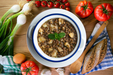 Lentil stew with potatoes, traditional Spanish tapa. Top view table with  decorations.