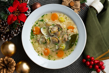 Rice, vegetable and clam soup, traditional Spanish tapa. Top view table with Christmas decorations.