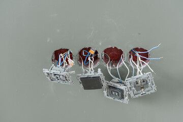 Exposed wiring and switch boxes are visible during a residential electrical installation in...
