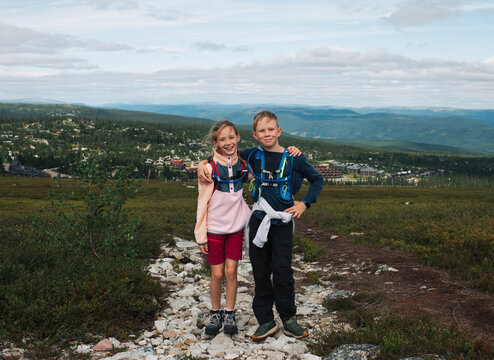 brother and sister stood hugging whilst hiking in Trysil, Norway