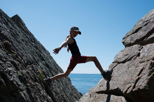 girl happily climbing the rocks in Sk&aring;ne in Sweden