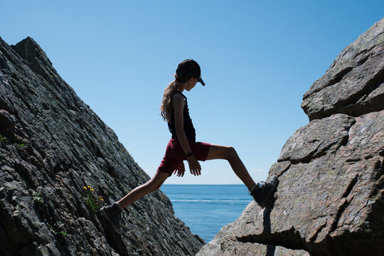 girl climbing rocks on the coastline in Sk&aring;ne, Sweden