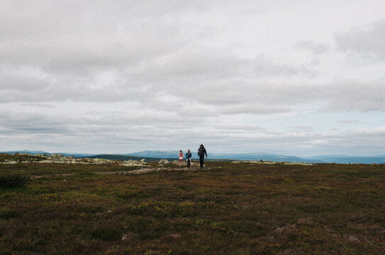 father and his son and daughter out hiking a mountain in Norway
