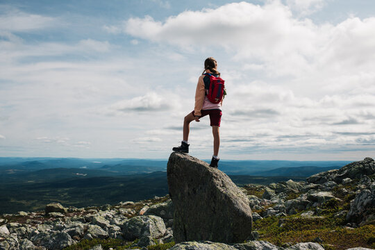 girl stood on a rock at the summit of a mountain in Trysil, Norway