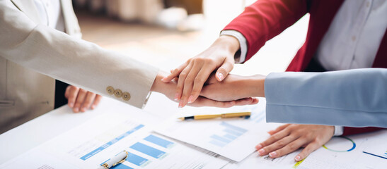 Three people shake hands in a business meeting