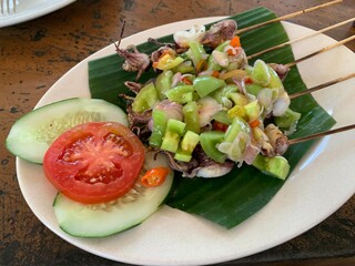 Balinese Grilled Squid with Dabu Dabu Chili Sauce. Spicy Indonesian condiment sambal made of tomato, garlic and shallot with lemon basil