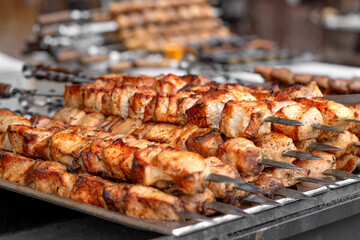 Pork kebab (shish kebab) in close-up. Meat fried on fire (barbecue) on skewers on the market counter. Delicious and mouth-watering shashlik