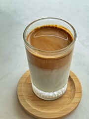 Dirty Coffee - A glass of espresso shot mixed with cold fresh milk on blurred background and copy space, Perfect drink for summer time.