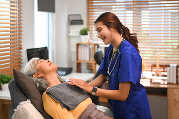 Physical therapist performing chest percussion on senior patient to help loosen and drain secretions from her lungs
