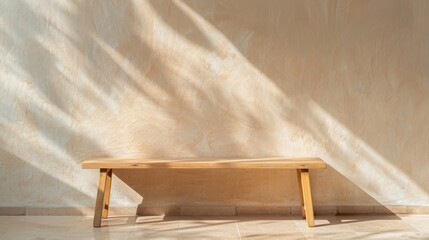 A wooden bench rests in a sunlit room, casting shadows on a smooth floor while enhancing the minimalist decor's tranquility