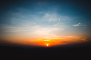 Majestic Mountain at Sunset with Sky and Cloudscape, Beautiful Landscape Captured in the Evening Light as the Sun Sets and Horizon Glows Orange, Transitioning from Dusk to Dawn with Sunlight