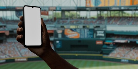 Black African-American male using smartphone with a blank white screen. Stadium, baseball, diamond apps mockup. Vertical phone orientation