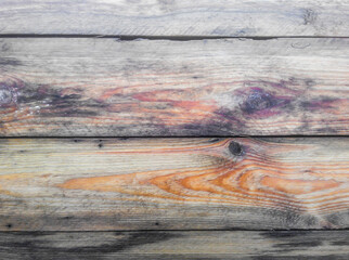 Raw boards with a beautiful multi colored pattern and knots. The structure and roughness are visible