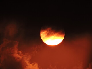 Naklejka premium the sun with red sky and black clouds, very horror and scary