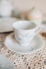 a teacup and saucer are on a table with a plate, tea time