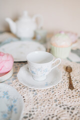 a teacup and saucer are on a table with a plate, tea time